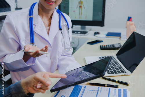 An Asian female specialist attentively consults a patient, discussing symptoms and treatment options with care. She listens closely, offering professional medical advice and support in a calm