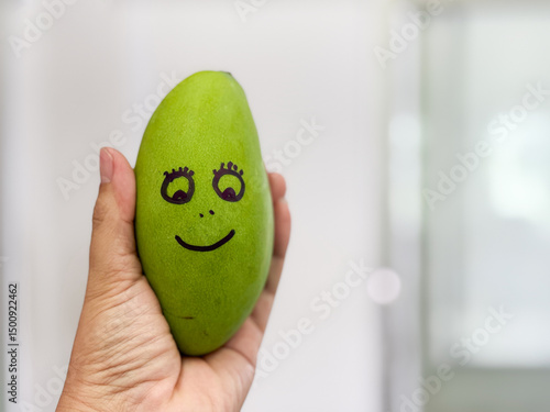 Holding hands with mango, smiling Fresh greens near fruits, healthy and nature concept.