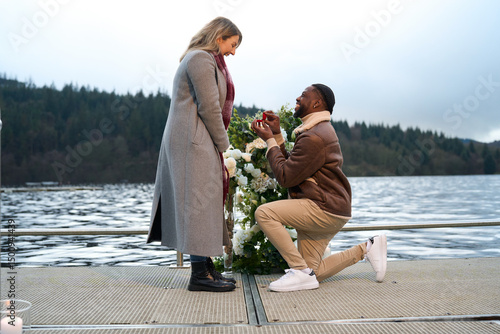 Papier peint Smiling man proposing marriage to woman on bridge