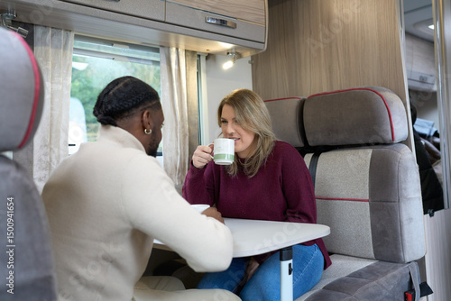 Couple relaxing at table in camper van