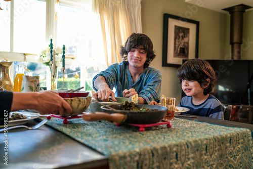 Young man with little sister dining during Eid Celebration