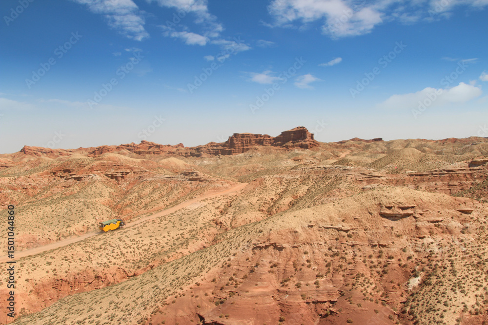 Fototapeta premium SUV car moving on dusty road at Pingshan Hu Grand Canyon in summer, Zhangye City, Gansu Province in China
