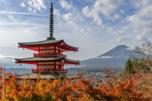 Scenic autumn view from Arakurayama Sengen Park captures Chureito Pagoda framed by golden-red trees, with Mount Fuji towering in the distance under a bright sky