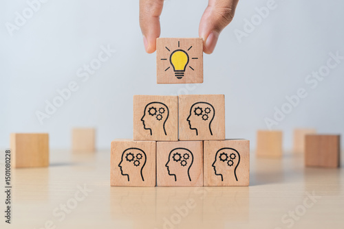Concept creative idea and innovation. Hand picked wooden cube block with head human symbol and light bulb icon