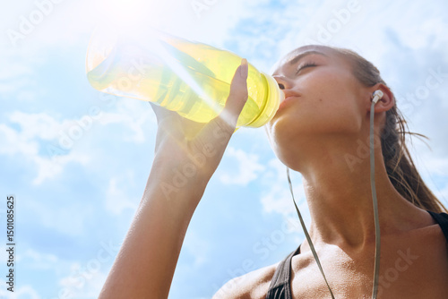 Woman drinking water at workout outdoors