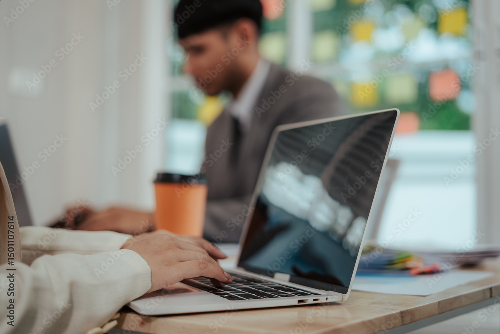Cheerful Asian businessman and woman looking at laptop screen, analyzing project success in office. Cheerful Asian businessman and woman looking at laptop screen, analyzing project success in office.