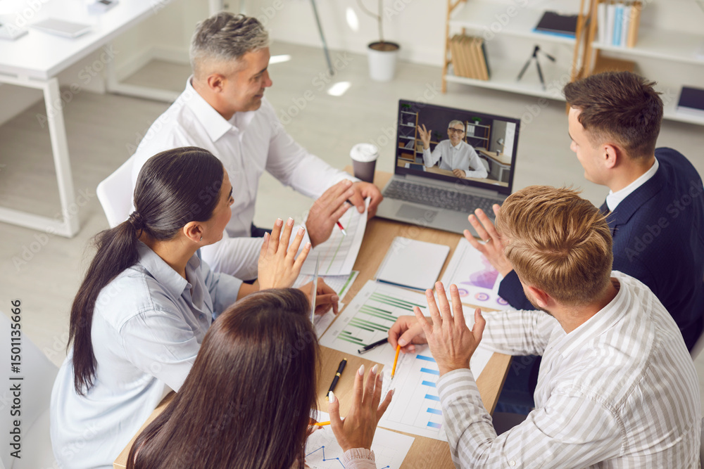Obraz premium Team of people meeting in office and having conference call with colleague. Group of men and women sitting together at table looking at screen of laptop computer. Online business communication concept
