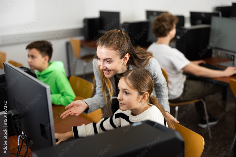 Fototapeta premium Positive woman teacher together with the girl teaches how to work on the computer