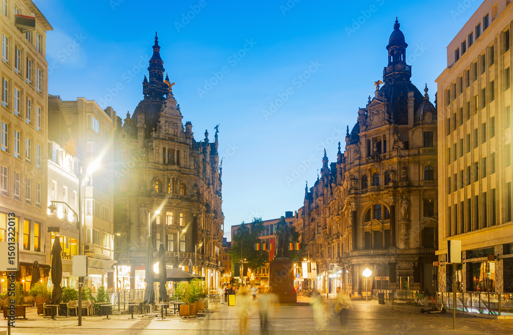 Fototapeta premium Evening view of illuminated Leysstraat street in Belgian city of Antwerp overlooking statue of Flemish baroque painter David Teniers Younger