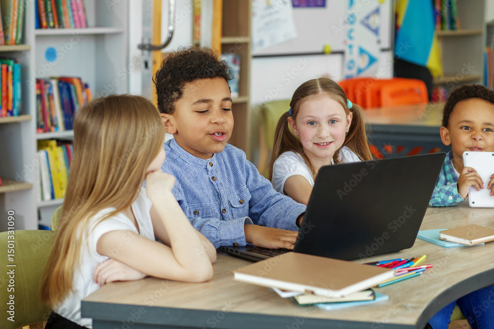 Multiracial group of children learning together on laptop in school. Back to school. Multiracial group of children learning together on laptop in school. Back to school.
