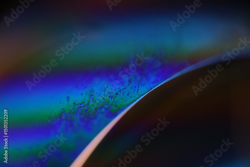 Bright rainbow spots of liquid on black background, blue colours, surrealistic pattern, fantastic smooth movement