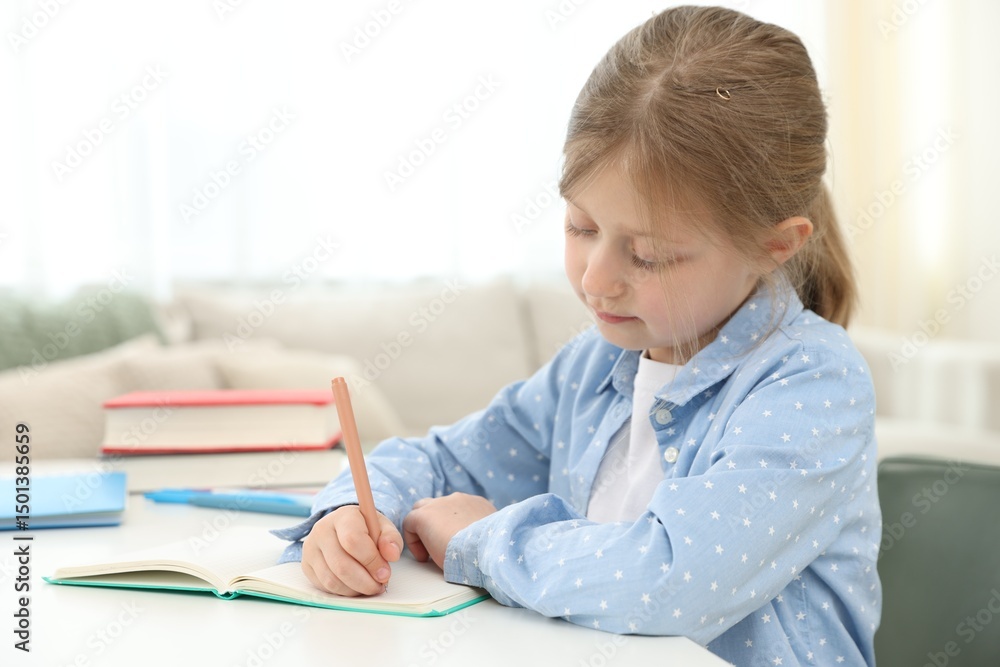 Little girl doing homework at table indoors Little girl doing homework at table indoors