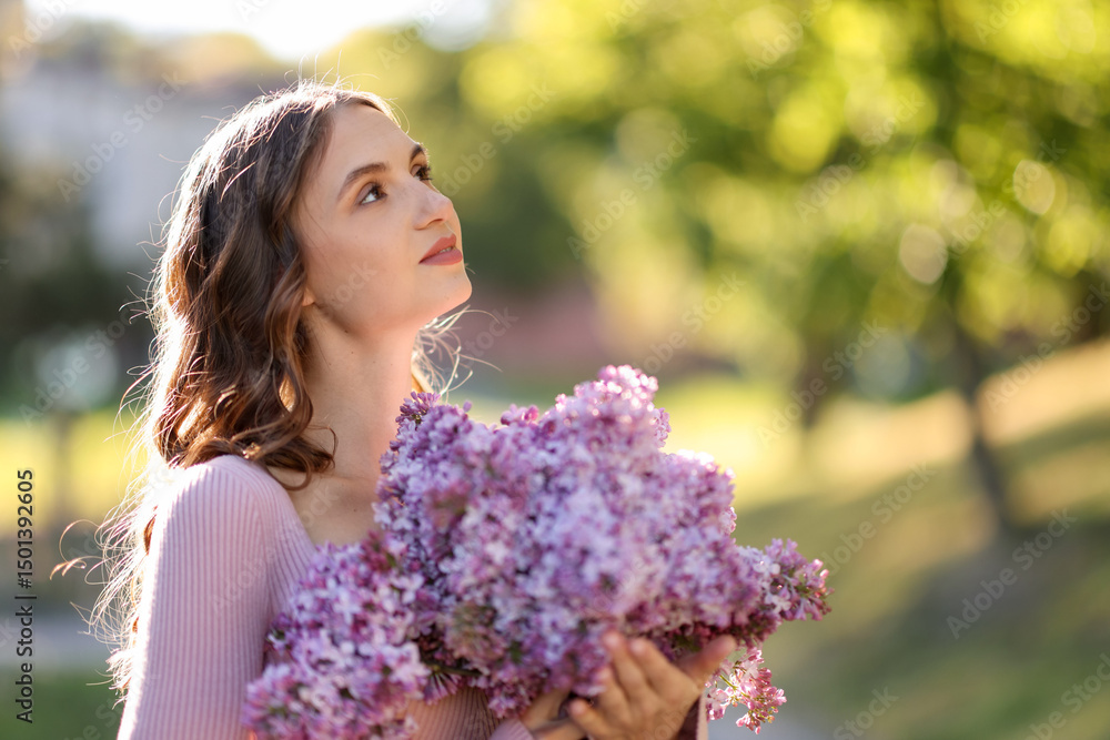 Fototapeta premium Beautiful woman with bouquet of lilac flowers outdoors in morning