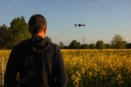Dron, operator drona podczas pracy. Nagrywanie filmów z lotu ptaka dronem. Dron w rolnictwie. Filmy z góry. 