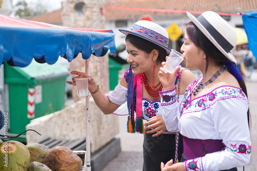 Wallpaper Mural Two indigenous women in vibrant, traditional clothing are enjoying refreshing drinks from a street vendor Torontodigital.ca