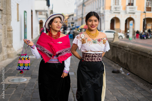 Indigenous otavalo women showing traditional clothes walking in ecuadorian city