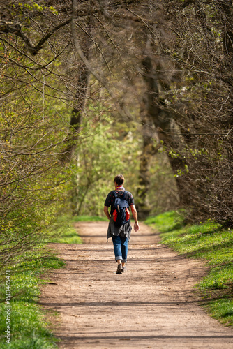A woman walks through a forest in Thuringia, dressed fashionably smart. This helps to stimulate the circulation and clear the mind. She is dressed smartly and has a fashionable backpack.