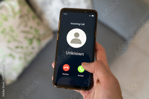 Concept of incoming call from unknown number. Hand holding smartphone.