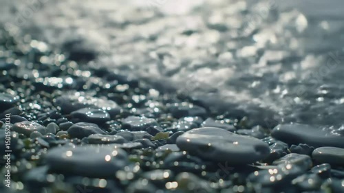 Waves Gently Lap At A Rocky Shoreline With Sparkling Sunlight