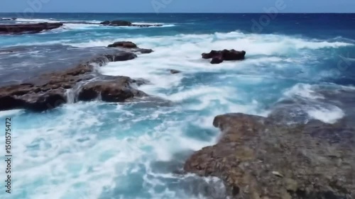 Ocean Waves Crashing Against Rocky Shoreline Underneath Bright Cloudy Sky