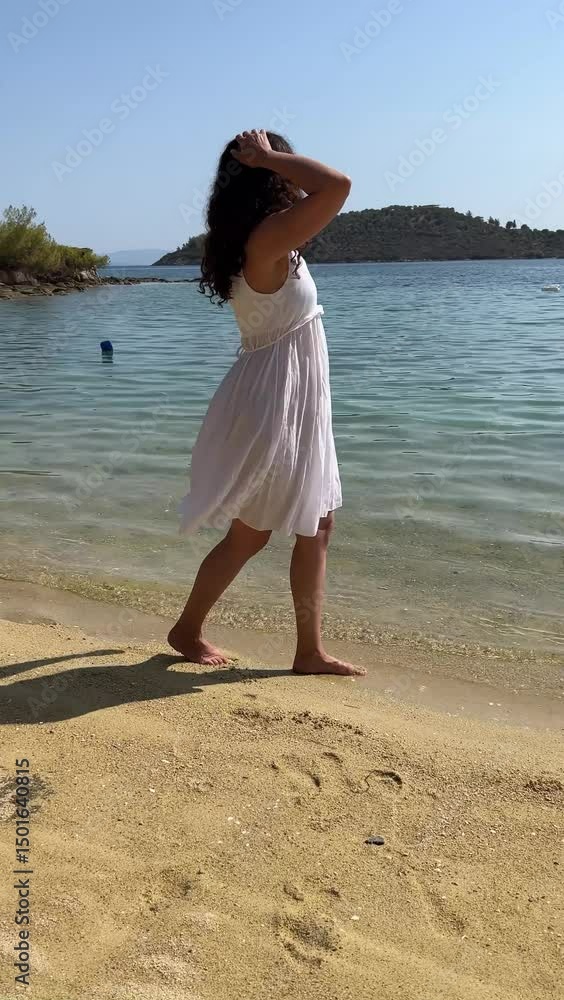 a woman brunette in a white dress walks along the sea coast, female feet are barefoot a woman brunette in a white dress walks along the sea coast, female feet are barefoot