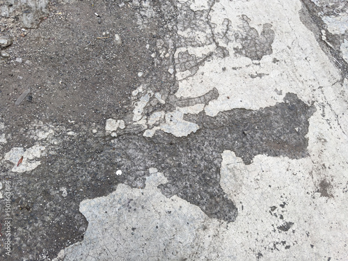 Quadro su tela Worn concrete surface with cracked texture and exposed dirt on damaged urban pav
