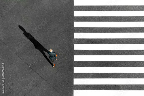 Tokyo City, Japan - 16 November 2020: Aerial view of zebra crossing with black and white stripes and a man in suit crossing, tokyo city, tokyo prefecture, japan.