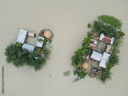 Aerial view of flood water surrounding homes and boats in a suburban landscape, Jatrapur, Kurigram, Bangladesh.