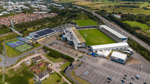 Aerial view of sandy park stadium surrounded by green fields and urban infrastructure, Exeter, United Kingdom.