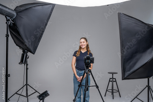 Blogger poses for a photoshoot in a studio setup with professional lighting and camera equipment