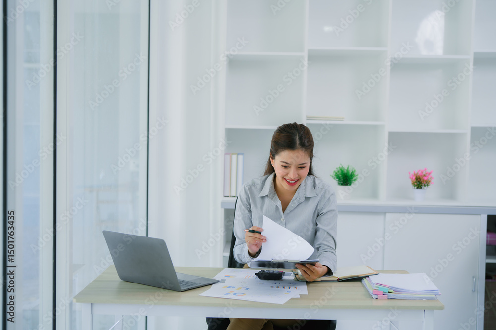 Businesswoman analyzing financial charts and using calculator in office Businesswoman analyzing financial charts and using calculator in office