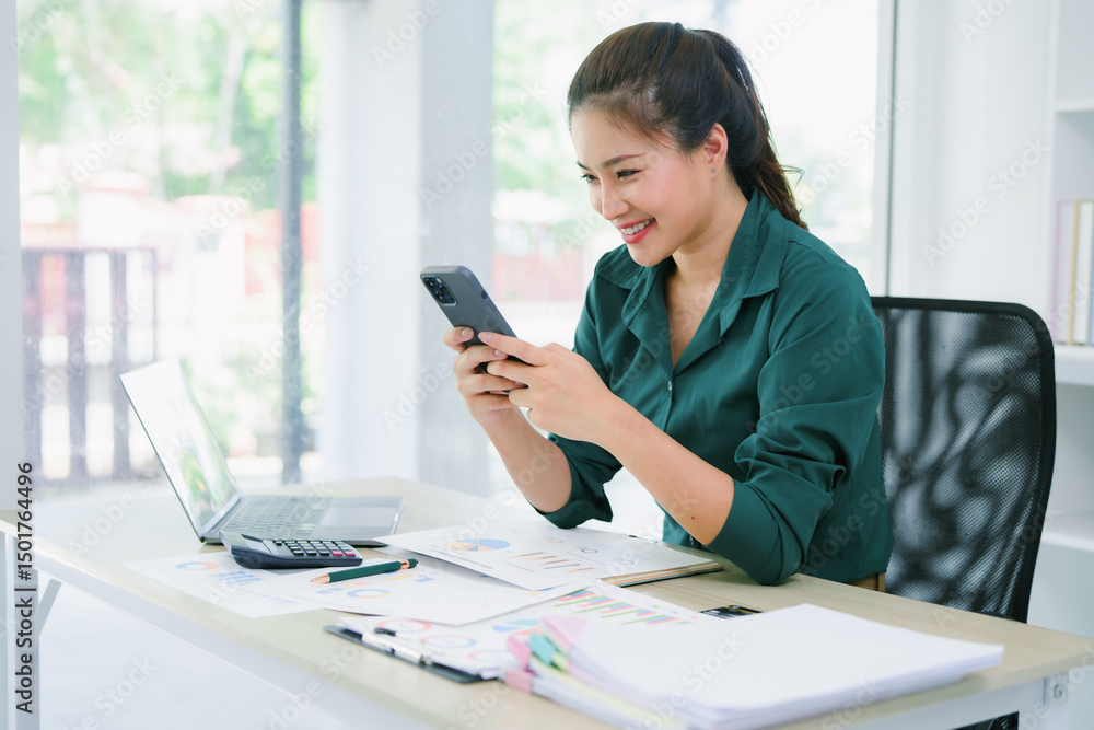 Beautiful office lady using mobile phone and thinking about her business. Sitting at desk with laptop and documents. Beautiful office lady using mobile phone and thinking about her business. Sitting at desk with laptop and documents.
