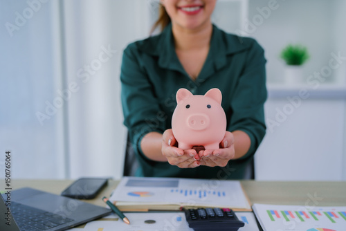 Young beautiful asian woman sitting at table and looking at growing stack of coins, financial debt employee bonus concept.