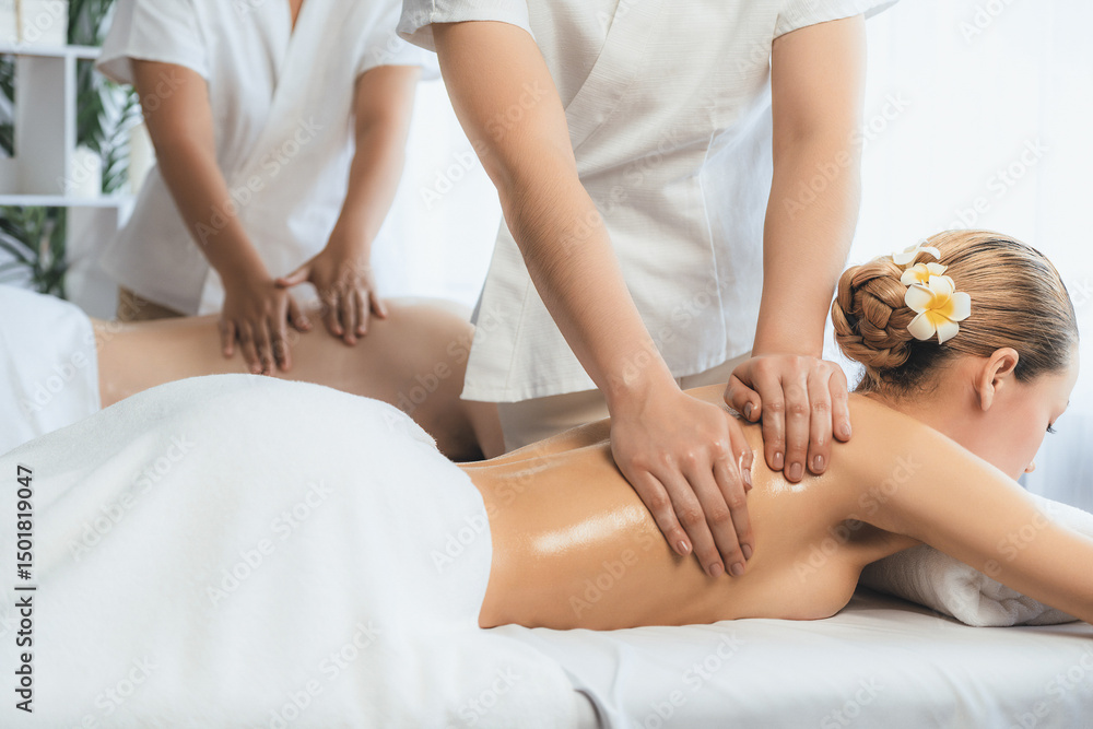 Fototapeta premium Caucasian couple customer enjoying relaxing anti-stress spa massage and pampering with beauty skin recreation leisure in day light ambient salon spa at luxury resort or hotel. Quiescent