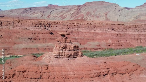 Mexican Hat rock formation in southern Utah. Low angle rotating pan shot that shows the formation, river below, and Raplee Ridge formation in the background.