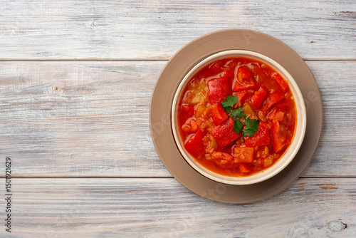 Traditional Hungarian dish lecho or Lecso or Letscho. Stew with peppers, tomatoes and onions in bowl on wooden background.