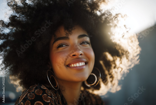 Portrait of a beautiful young woman with stunning afro hair, smiling joyfully as the sun sets, capturing the essence of carefree happiness