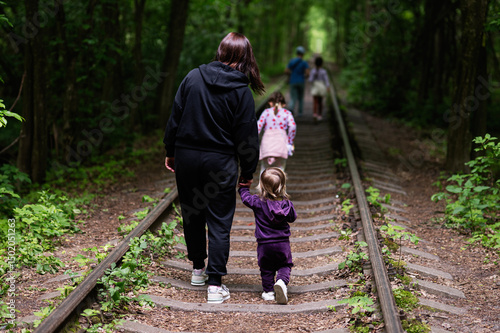 Wall Mural Family walking together along forested railroad track creating cherished memorie