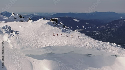 Mountaineers walking on snowy mountain ridge