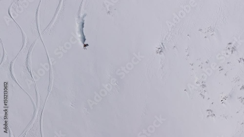Snowboarders and skiers riding down a snowy mountain slope