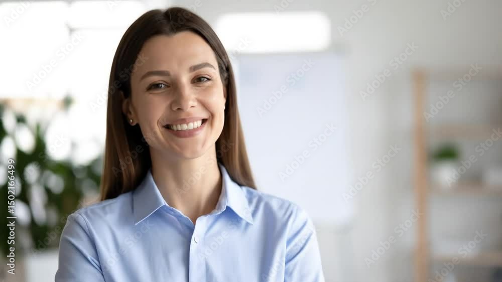 Smiling confident businesswoman portrait with crossed arms in modern office setting Smiling confident businesswoman portrait with crossed arms in modern office setting