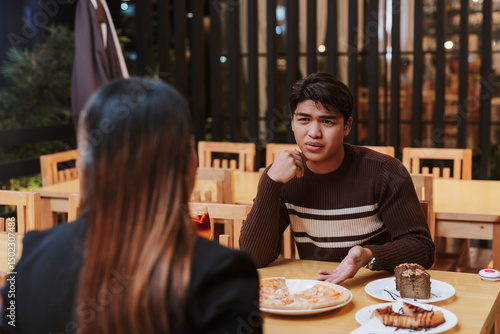 Fototapete A frustrated young man expresses displeasure during a restaurant date with an older woman, showing concern or being finicky about the subpar food or conversation