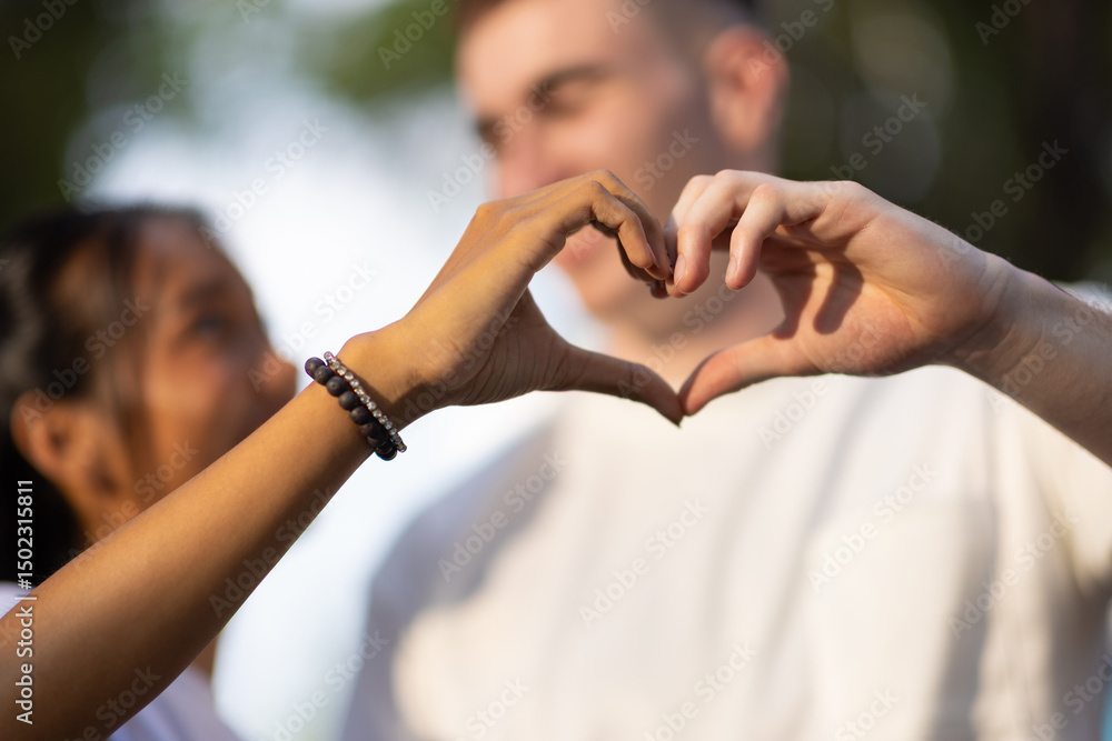 Young ethnic couple making heart shape with hand. Young ethnic couple making heart shape with hand.