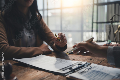 Lawyers working together pointing at contract, reviewing and discussing legal terms during a meeting in the office