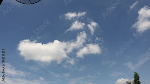Time lapse of moving white clouds with blue sky background