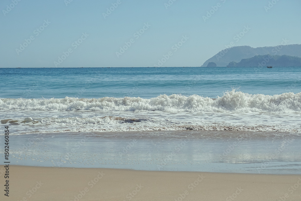 Calm Waves Approach the Beach with Green Cliffs on the Side at wawaran beach pacitan east java indonesia Calm Waves Approach the Beach with Green Cliffs on the Side at wawaran beach pacitan east java indonesia