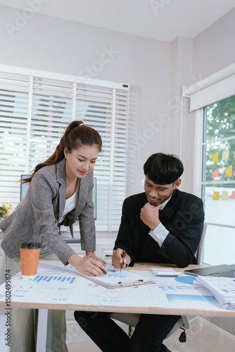 Wallpaper Mural Business professionals analyzing investment graphs and financial charts on laptops during a strategic meeting in a modern office environment. Torontodigital.ca