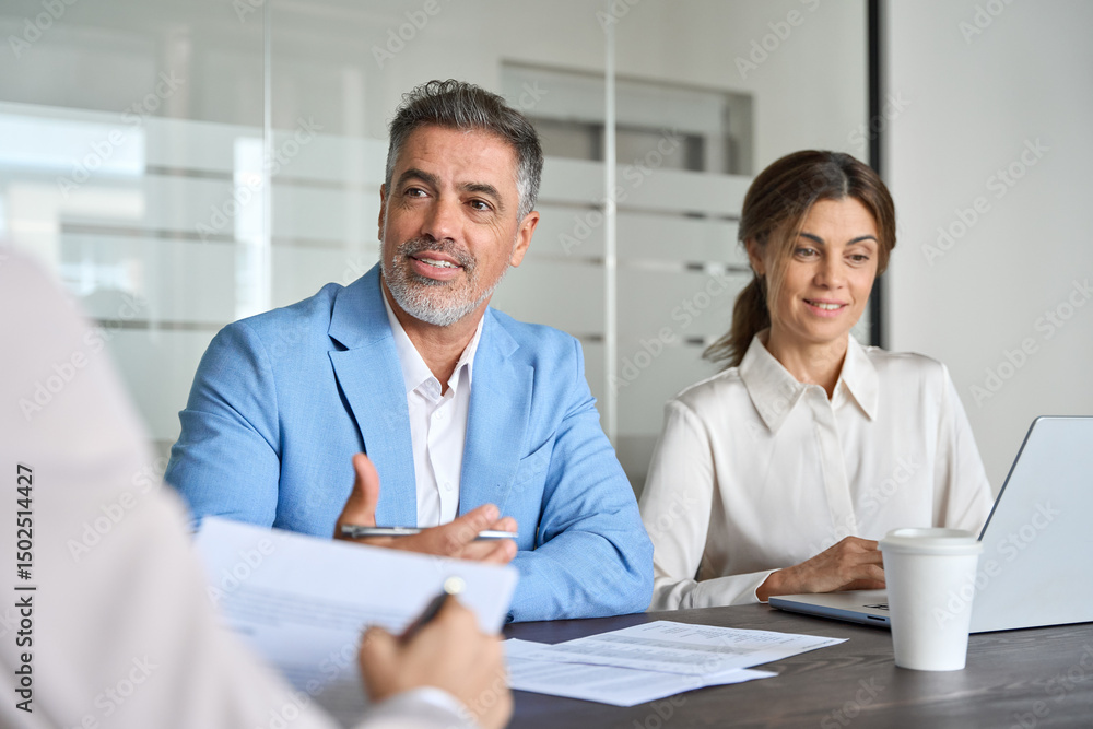 Obraz premium Busy business people executive team working together talking at meeting. Happy corporate board group, smiling mature male manager working with colleagues partners in office, consulting client investor
