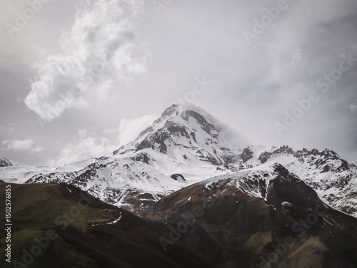 Wallpaper Mural Majestic snow-capped mountain peak under a cloudy sky. Torontodigital.ca