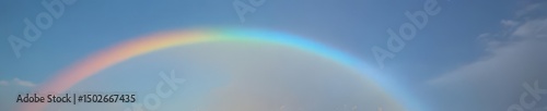 A vibrant arc of color, a rainbow magically appearing in a cloudless azure sky , heavenly, art photo